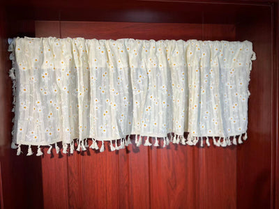 White semi-sheer curtain with green and grey floral pattern and cream tassel trim, hanging in a window. - Image 7