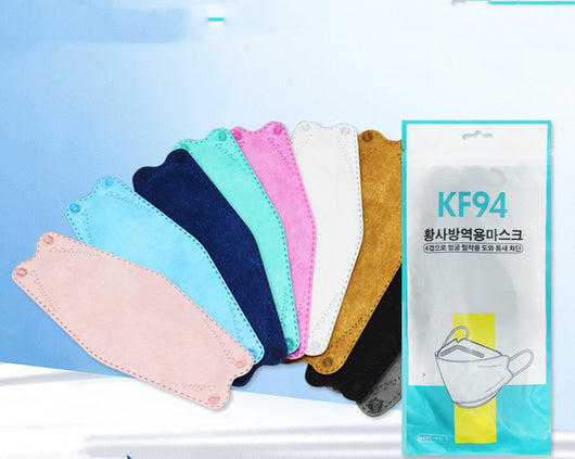 A fan of multi-colored KF94 fish-shaped masks in pink, blue, teal, white, gold, black, and grey, next to a packaged mask. - Image 30