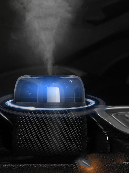 Black car aroma diffuser humidifier with blue light, wireless charging, and automatic spray, shown with six essential oil bottles. - Image 3