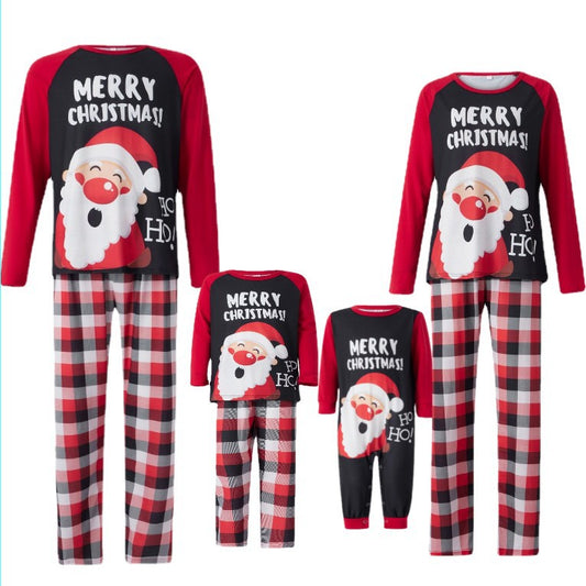 Family matching Christmas pajamas with Santa Claus graphic and "Merry Christmas!" text on black and red tops, paired with red and black plaid pants.