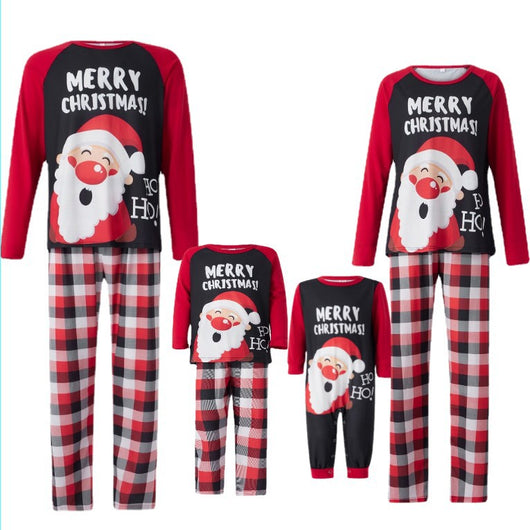 Family matching Christmas pajamas with Santa Claus graphic and "Merry Christmas!" text on black and red tops, paired with red and black plaid pants.