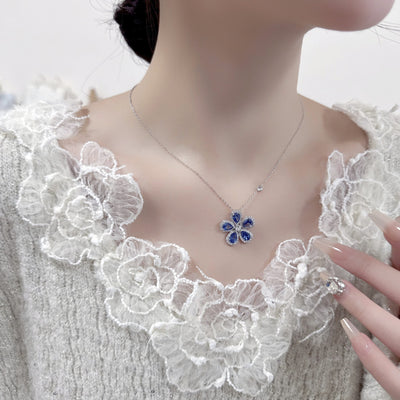 Elegant jewelry set with a silver-tone necklace and matching stud earrings, featuring blue and clear floral gemstones. - Image 7