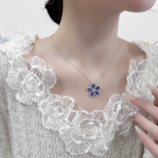 Elegant jewelry set with a silver-tone necklace and matching stud earrings, featuring blue and clear floral gemstones. - Image 7