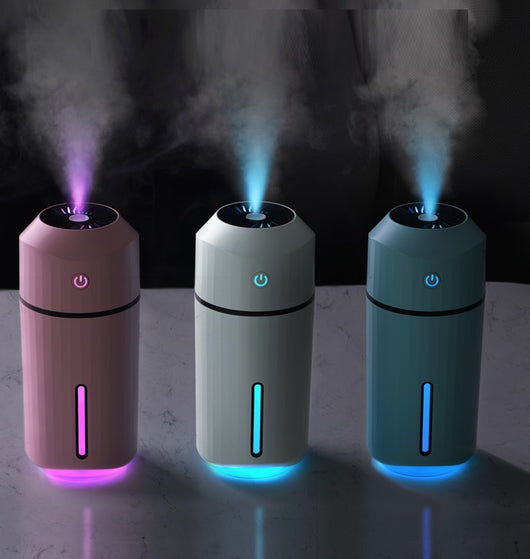 Pink portable humidifier with a power button, water level indicator, USB charging cable, and two cotton swabs.
