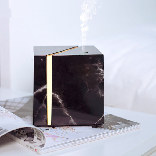 White and grey marble pattern ultrasonic aromatherapy diffuser with a vertical gold LED light strip and power button. - Image 3