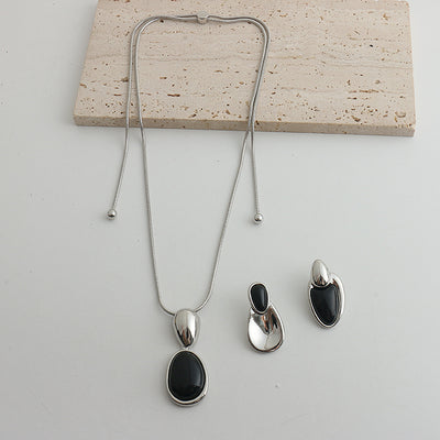 Pair of gold-toned irregular earrings with black onyx-like inserts, featuring a modern, abstract design. - Image 21