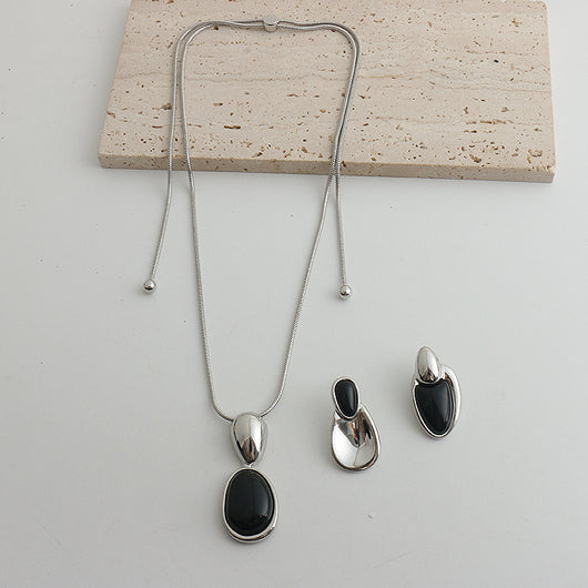 Pair of gold-toned irregular earrings with black onyx-like inserts, featuring a modern, abstract design. - Image 21