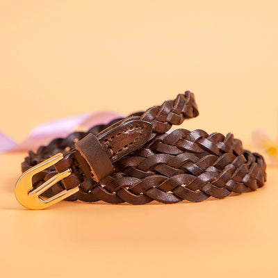 Women's braided brown leather belt with a D-shaped gold-tone pin buckle, coiled on a peach background. - Image 3