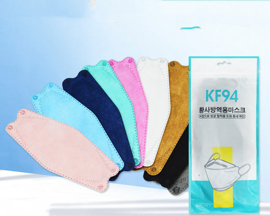 A fan of multi-colored KF94 fish-shaped masks in pink, blue, teal, white, gold, black, and grey, next to a packaged mask. - Image 18