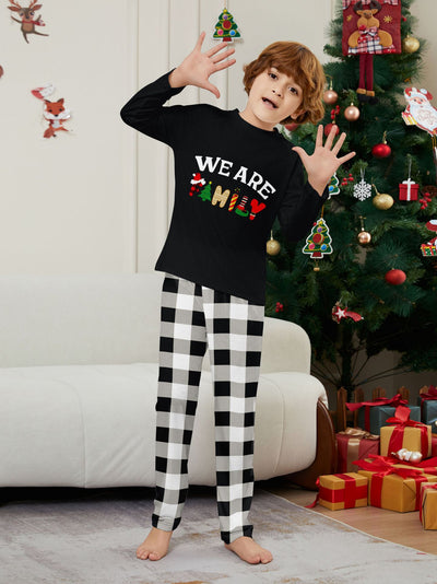 Family of four wearing matching black long-sleeve pajamas with "WE ARE FAMILY" text and black and white plaid bottoms. - Image 8