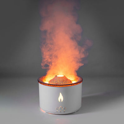 White ultrasonic essential oil diffuser with orange flame effect mist, alongside a gift set of Lavender, Peppermint, Tea Tree, and Sweet Orange essential oils. - Image 6
