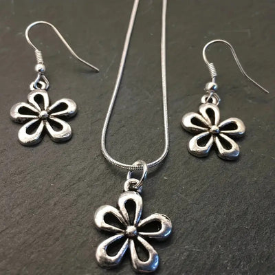 Silver-colored snake chain necklace with a delicate flower pendant and an adjustable lobster clasp closure.