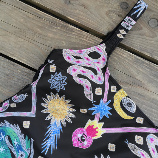 Black one-piece swimsuit for women featuring a vibrant multi-color print with dragons, suns, moons, and stars. - Image 10