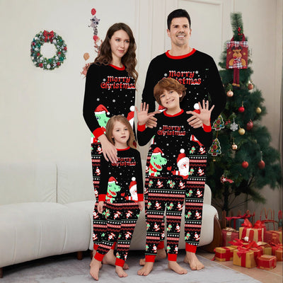 Man wearing black Christmas pajamas with a cartoon dinosaur, Santa Claus, and "Merry Christmas" text, standing by a decorated tree.