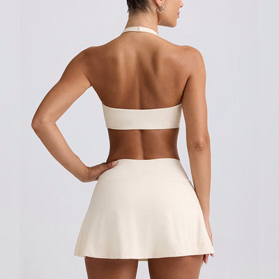 Light pink halter neck sports bra and high-waisted leggings workout set on a model. - Image 2