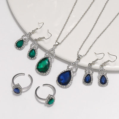 Light luxury jewelry set with silver-tone necklace, dangle earrings, open ring, and bracelet, all featuring emerald green teardrop and oval stones with clear rh - Image 3