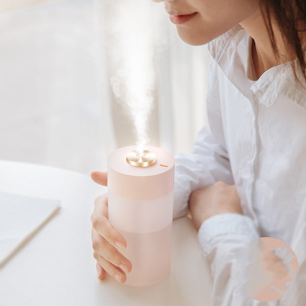 White and clear cylindrical car air humidifier with a gold top accent, designed for in-car air hydration.