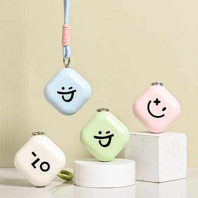 Light green square hand warmer with rounded corners and a black smiley face, hanging from a two-tone lanyard. - Image 2
