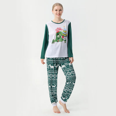 Woman in a Christmas pajama set with a white top, green sleeves, dinosaur graphic, and green fair isle pants. - Image 9