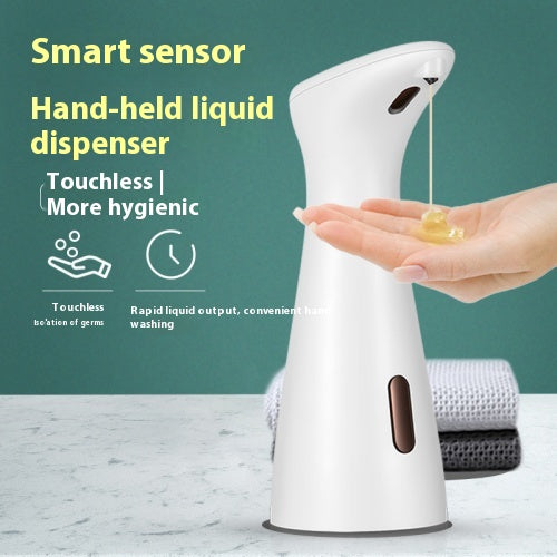 White automatic soap dispenser with an infrared sensor, dispensing blue liquid soap onto an outstretched hand. - Image 7