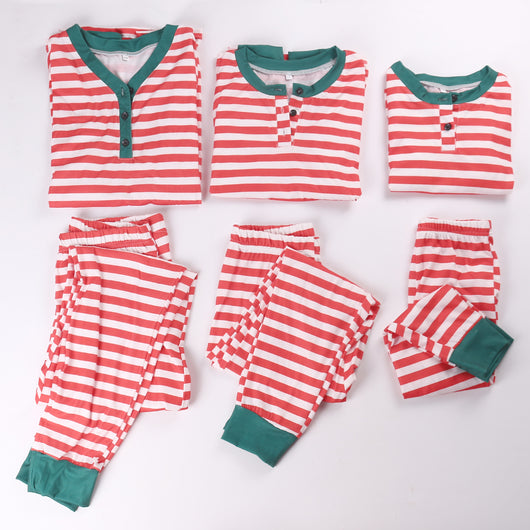 Family of six wearing matching red and white striped long-sleeved pajamas with green cuffs and festive hats. - Image 9