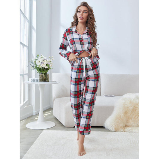 Woman wearing a red, white, and green plaid two-piece pajama set with a button-up top and long pants. - Image 3