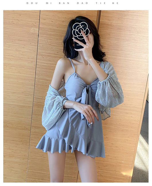 Women's light blue one-piece swimsuit with tie-front bust and ruffled hem, paired with a sheer shimmery cover-up. - Image 7
