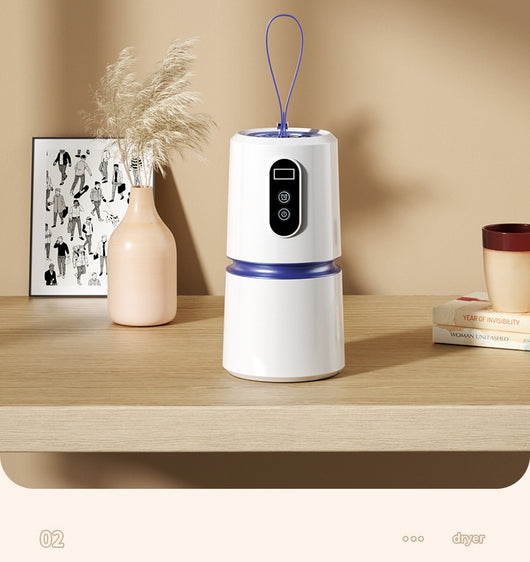White and blue mini household air dryer with a digital display and hanging loop, shown next to a gold smartphone. - Image 14