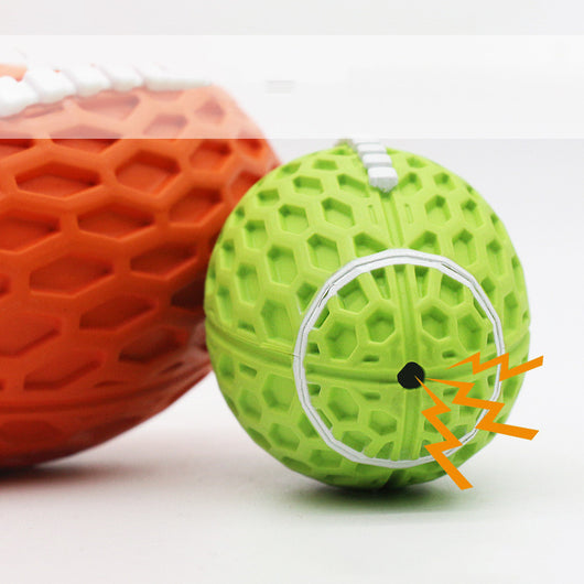 Orange rubber rugby ball dog toy with honeycomb texture and white laces, being squeezed by a hand. - Image 10