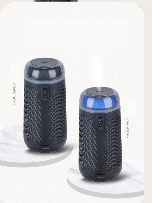 Black car aroma diffuser humidifier with blue light, wireless charging, and automatic spray, shown with six essential oil bottles. - Image 4