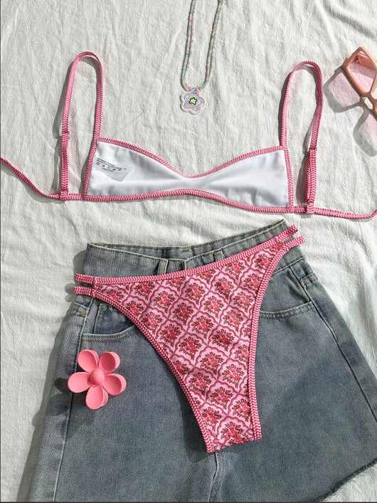Black bandeau bikini swimsuit with thin straps and a gold-toned abstract ring detail on the top, paired with matching string bottoms. - Image 22