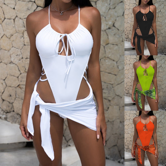 Women's neon green one-piece swimsuit with a tie-front halter neck and side cut-outs, paired with a matching snake print sarong.