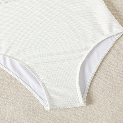 White textured one-piece swimsuit with deep V-neck and wooden O-ring detail, styled with a light-wash denim jacket. - Image 8