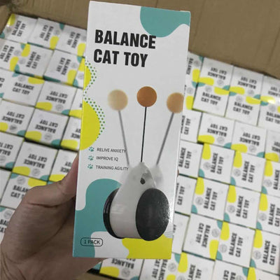 White and black self-rotating cat toy with an orange ball on a flexible rod, showing motion blur. - Image 26
