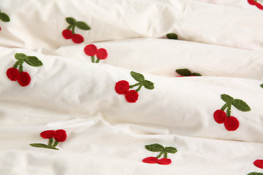 White pure cotton fabric with embroidered red cherries and green leaves, draped to show texture. - Image 9
