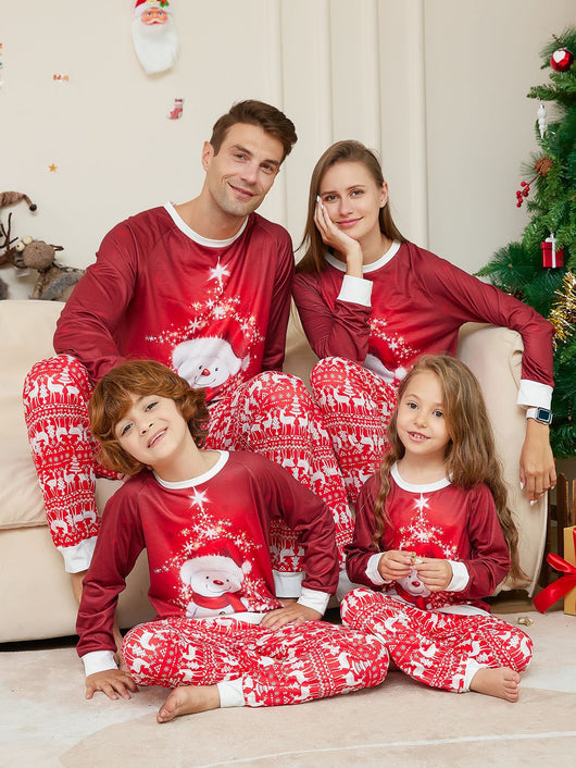 Family of four wearing matching red Christmas pajamas with snowman tops and reindeer fair isle pants, sitting by a Christmas tree. - Image 7