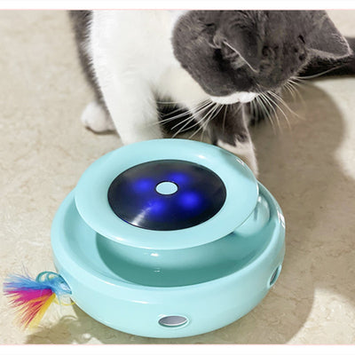 Grey and white cat observing a blue electric cat toy with a feather attachment and glowing blue lights. - Image 6