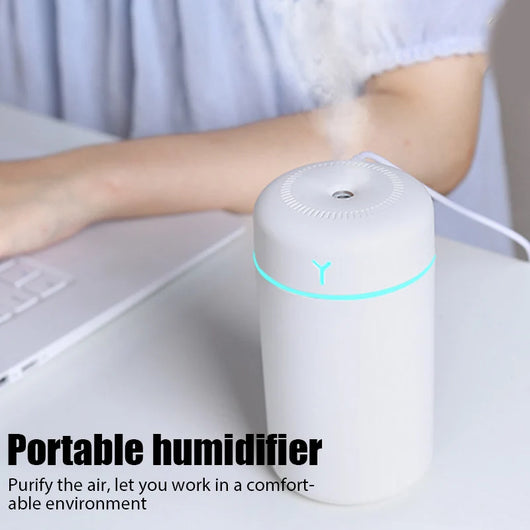 Pink portable humidifier with a blue LED light band, emitting fine mist, on a white pedestal. - Image 17
