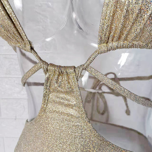Woman wearing a shimmering gold one-piece swimsuit with a halter neck, crisscross straps, and stylish cut-out details. - Image 16
