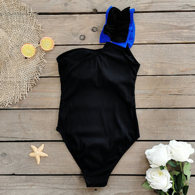 Black one-shoulder ribbed one-piece swimsuit with a ruffled blue and black strap, ideal for women's swimwear. - Image 18