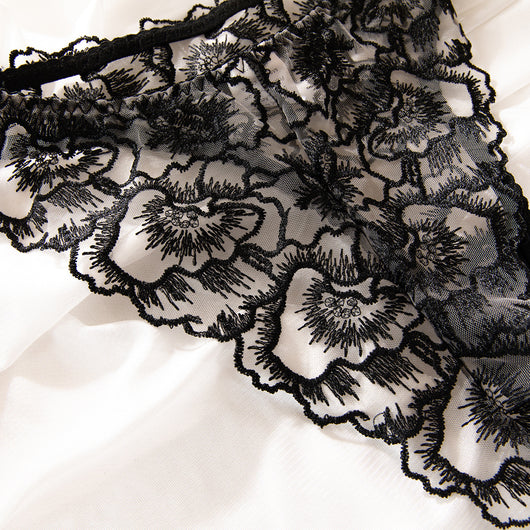 Black embroidered lace bra and thong set with transparent design and steel ring, displayed on white fabric. - Image 8