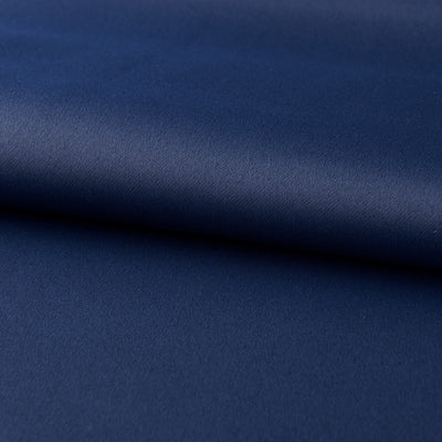 Dark blue blackout curtains with silver grommet tops hanging on a rod in a modern bedroom setting. - Image 10