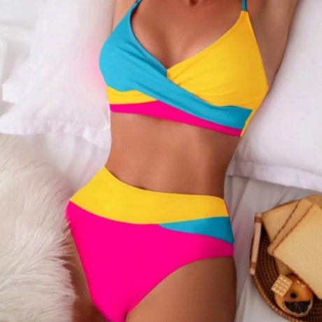 Woman wearing a blue color block split swimsuit with a wrapped front bikini top and high-waisted briefs.