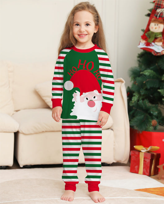 Woman wearing a green, red, and white striped Christmas pajama set with a Santa Claus graphic on the top. - Image 5