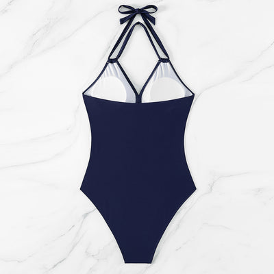 Woman in a green halter-neck one-piece swimsuit with cross-strap design and mesh cutouts, on a beach. - Image 20