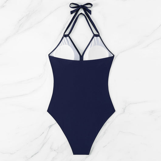 Woman in a green halter-neck one-piece swimsuit with cross-strap design and mesh cutouts, on a beach. - Image 20