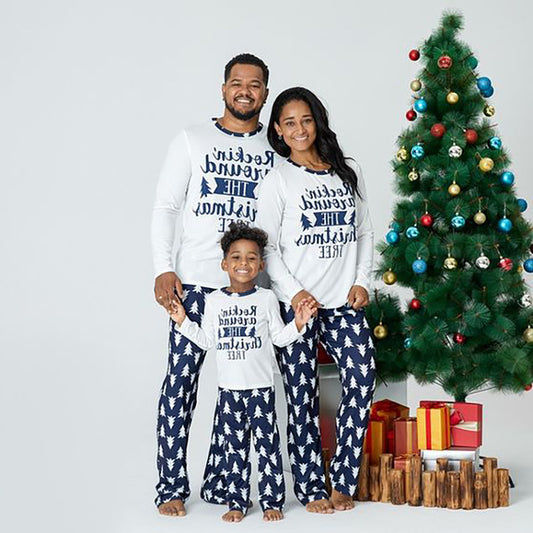 Family of three wearing matching white and navy blue Christmas pajamas with "Rockin' around THE Christmas TREE" text. - Image 2