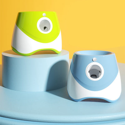 Two automatic dog ball throwers, one yellow and white, one green and white, on a wooden desk. - Image 3
