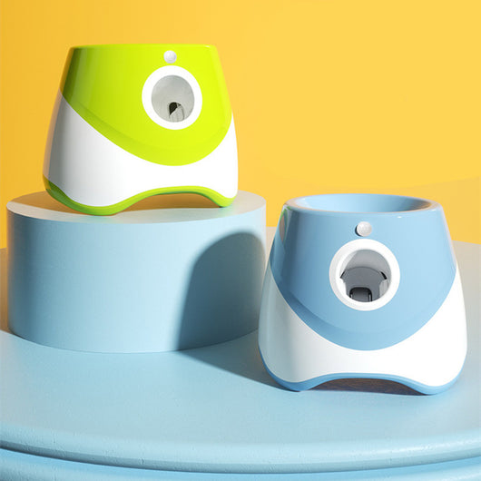 Two automatic dog ball throwers, one yellow and white, one green and white, on a wooden desk. - Image 3