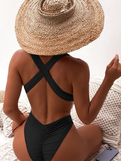 Woman in a black one-piece swimsuit with a deep V-neck and criss-cross waist cutouts, wearing a straw hat. - Image 16